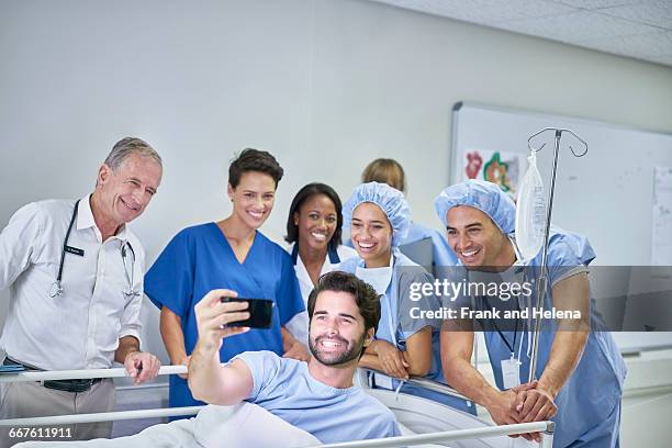 patient in hospital bed taking selfie with doctors and nurses - operating gown stock pictures, royalty-free photos & images