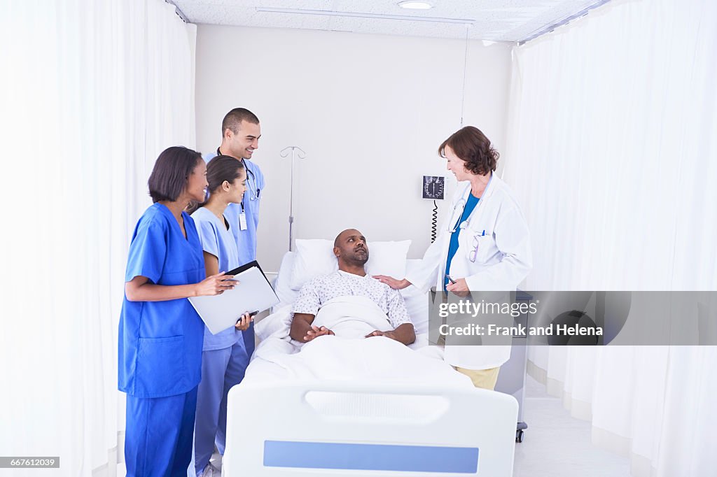 Doctors and nurses surrounding patient in hospital bed