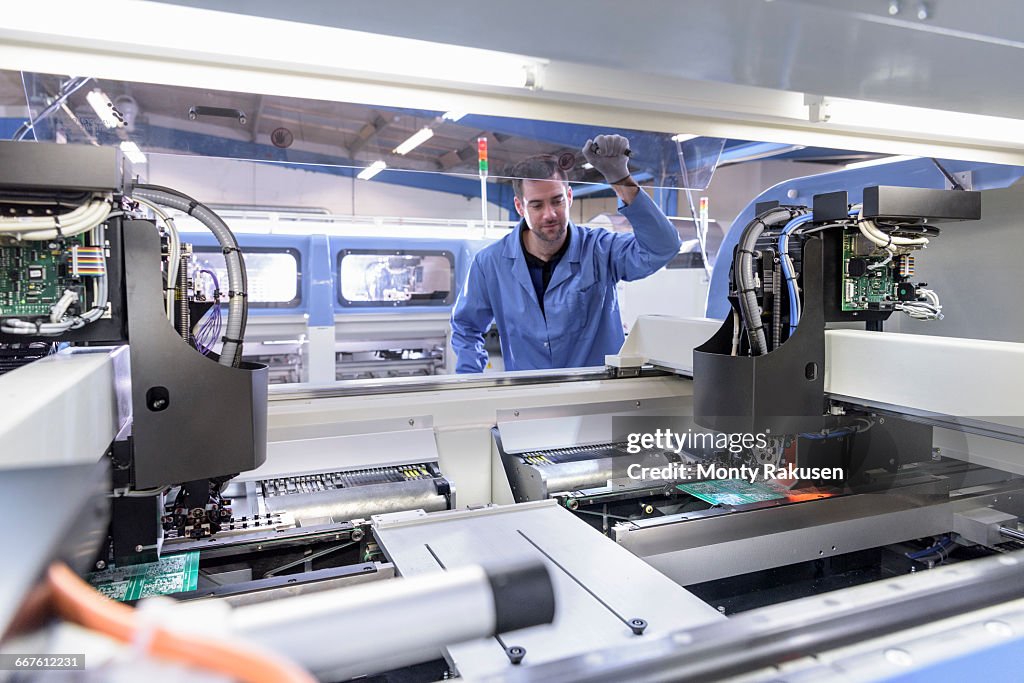 Robot placing components onto circuit board in circuit board assembly factory
