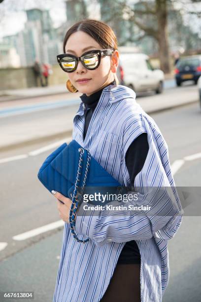 Fashion buyer for Restir Maiko Shibata wears a Chanel bag, Soya sunglasses, Balenciaga shirt and Holly Ryan earrings on day 4 of London Womens...