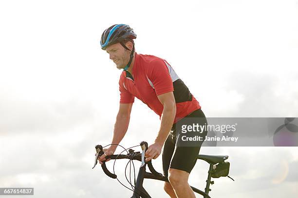 cyclist standing out of saddle - saddle stock pictures, royalty-free photos & images