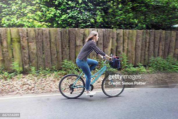 young woman cycling on rural road - walberswick suffolk stock pictures, royalty-free photos & images