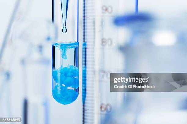 chemical reaction-pipette 0.5m solution of copper sulfate (cuso4) into 0.5m solution of sodium carbonate (na2co3). blue copper carbonate precipitate (cuco3) formed result: cuso4+na2co3->cuco3+na2so4 - reazione chimica foto e immagini stock