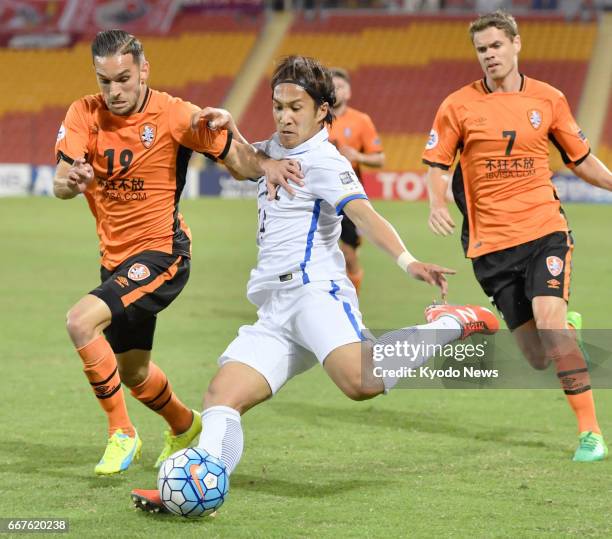 Jack Hingert of Australia's Brisbane Roar tries to block a kick from Takeshi Kanamori of Japan's Kashima Antlers in the first half of their Asian...