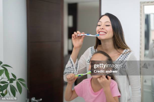 madre e hija en casa cepillarse los dientes - lavarse los dientes fotografías e imágenes de stock