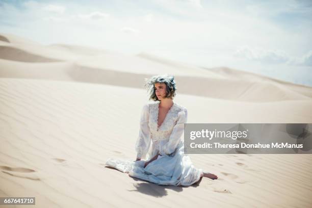 young lady sitting on sand dune - blythe stock pictures, royalty-free photos & images