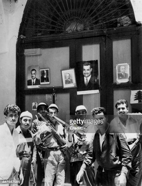Un groupe de rebelles en armes pose devant des portraits du colonel Nasser, le 09 Juillet 1958, dans un quartier de la vieille ville de Tripoli au...