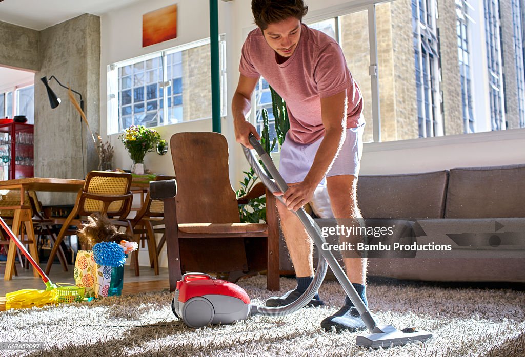 Man doing housework vacuuming