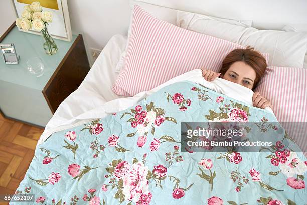 up view of a woman playing hide under the sheets - duvet stock pictures, royalty-free photos & images
