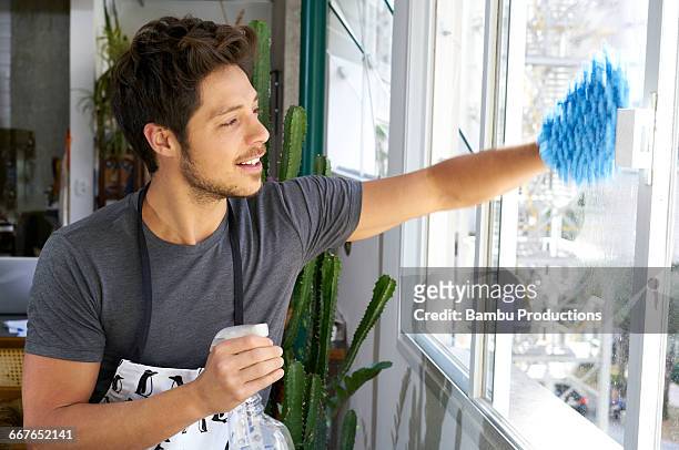 man cleaning window panes - men housework stock pictures, royalty-free photos & images