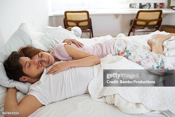 man and woman embracing in bed - romantic young couple sleeping in bed stock pictures, royalty-free photos & images