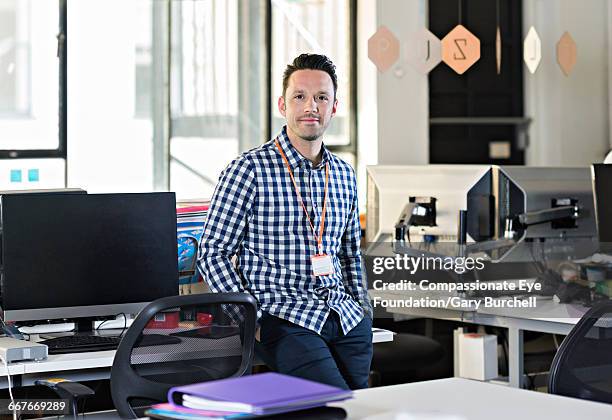 businessman standing in tech start-up office - gary burchell stock pictures, royalty-free photos & images