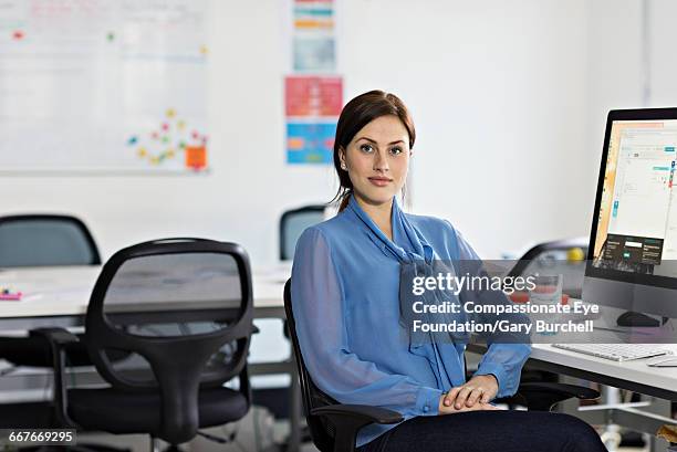 businesswoman sitting in tech start-up office - gary burchell stock pictures, royalty-free photos & images