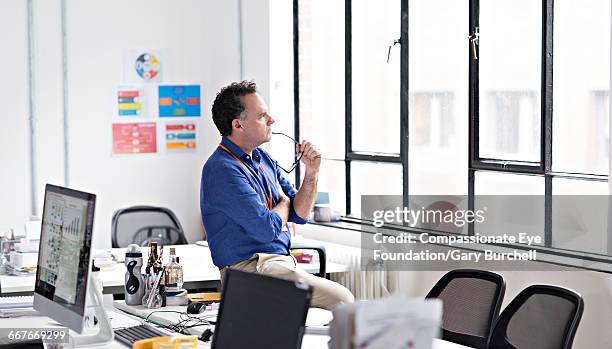 pensive businessman sitting in start-up office - gary burchell stock pictures, royalty-free photos & images