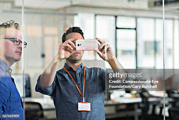 colleagues brainstorming in tech start-up office - gary burchell stock pictures, royalty-free photos & images