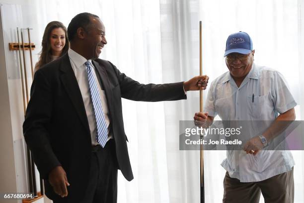 Housing and Urban Development Secretary Ben Carson shares a cue stick with Luis Figueroa as he visits Colllins Park apartment complex on April 12,...