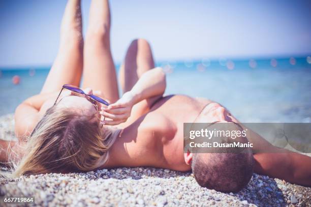 romantic couple lying in sea on tropical beach holiday - beach model stock pictures, royalty-free photos & images