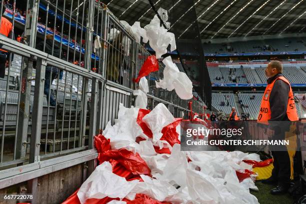 Volunteers have to remove, by police order, sheets for the choreography prior to the UEFA Champions League 1st leg quarter-final football match FC...