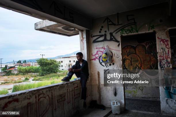 An Illegal migrant from Somalia sits and looks out at the sea as he stays with other migrants from Sudan, Somalia, and Syria in an abandoned factory...