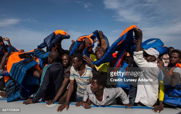 Italian sailors with the Uraniam Navy Ship rescue 109 African migrants from Gambia, Mali, Senegal, Ivory Coast, Guinea, and Nigeria, from a rubber...