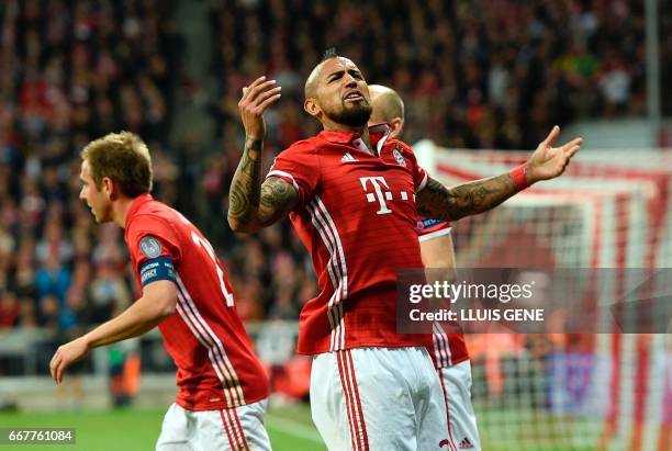 Bayern Munich's Chilean midfielder Arturo Vidal celebrates scoring the opening goal next to Bayern Munich's defender Philipp Lahm during the UEFA...