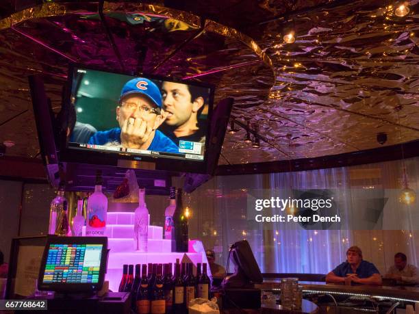 Visitors to the Crowne Plaze hotel bar in Downtown Dallas watch the baseball on TV...Dallas is a major city in Texas and is the largest urban center...