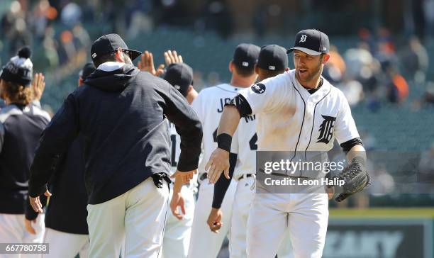 Alex Avila of the Detroit Tigers congratulates teammate Andrew Romine after the win over the Minnesota Twins on April 12, 2017 at Comerica Park in...