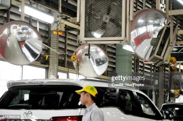 Workers examine and try out the final outcome of vehicles already out of the assembly at Toyota Motor Manufacturing Indonesia, Karawang, West Java,...