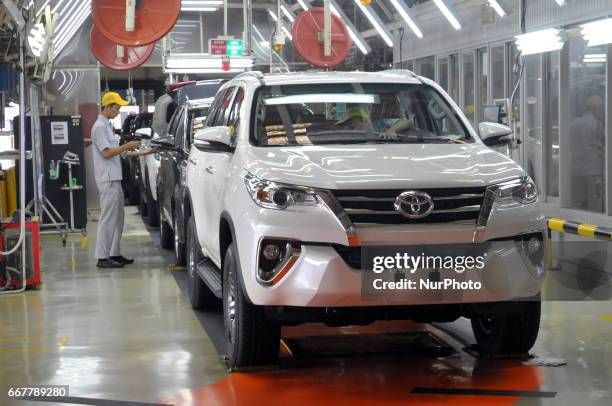 Workers examine and try out the final outcome of vehicles already out of the assembly at Toyota Motor Manufacturing Indonesia, Karawang, West Java,...