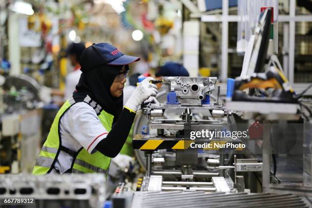 Workers ready to plug in a car engine at Toyota Motor Manufacturing Indonesia, Karawang, West Java, on April 4, 2017. The Company Toyota Motor...