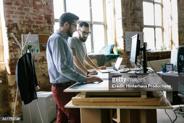 two men standing at a makeshift desk - makeshift desk stock pictures, royalty-free photos & images
