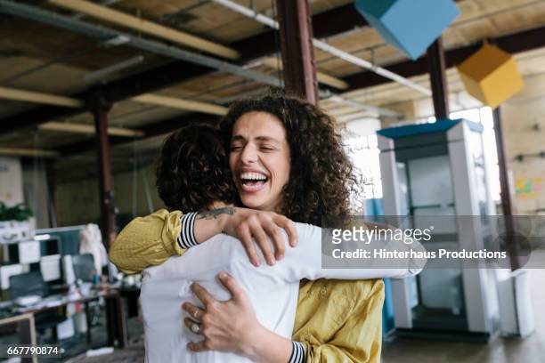 two co-worker hugging - success stock-fotos und bilder
