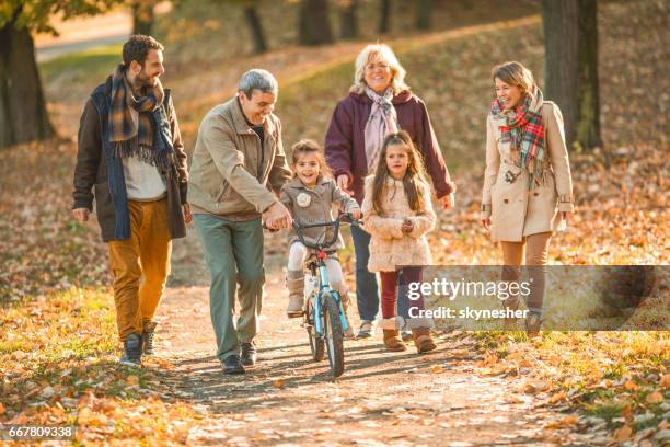 happy erweitert familie im herbst tag im park genießen. - fahrrad fahren großeltern mit kind stock-fotos und bilder