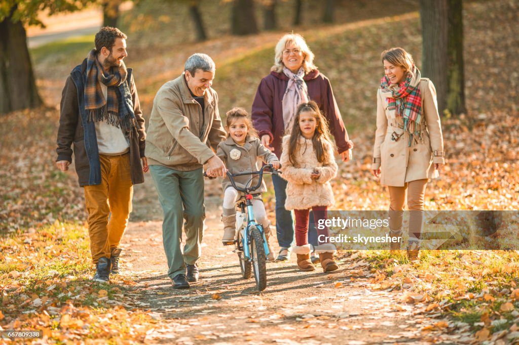 Happy estendido a família desfrutando em dia de Outono no parque.