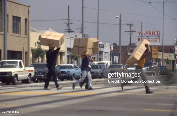 Looters take TV's across the street in widespread riots that erupted after the acquittal of 4 LAPD officers in the videotaped arrest and beating of...