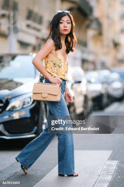 May Berthelot, Head of Legal at Videdressing.com and fashion blogger, wears a New Look yellow floral print sleeveless top, Claudie Pierlot blue denim...