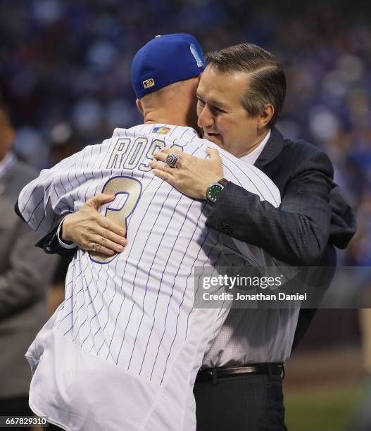 Chairman and owner Tom Ricketts of the Chicago Cubs hugs former player David Ross during a World Series Championship ring ceremony before a game...