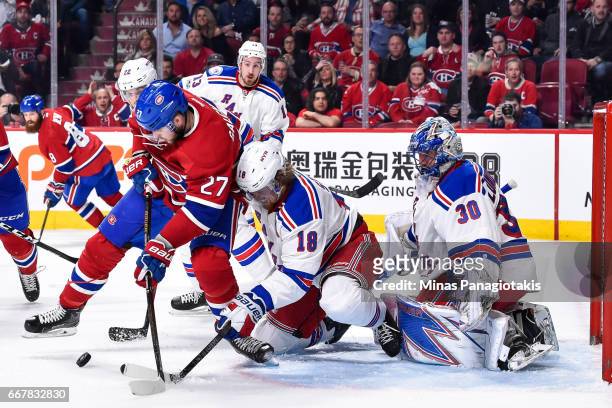 Alex Galchenyuk of the Montreal Canadiens and Marc Staal of the New York Rangers battle for the puck in front of Rangers goaltender Henrik Lundqvist...