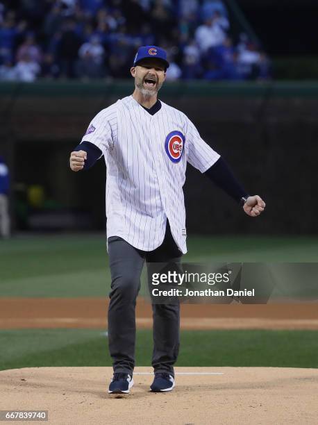 Former player David Ross of the Chicago Cubs smiles after throwing a ceremonial first pitch before a game against the Los Angeles Dodgers at Wrigley...