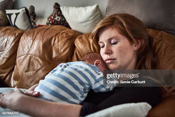 a mother and new born baby taking a nap together - stanchezza foto e immagini stock