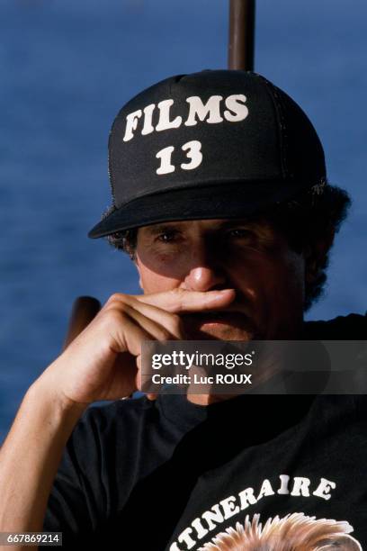 French director Claude Lelouch pendant wears a cap from his production house Films 13 on the set of his film Itineraire d'un Enfant Gate.