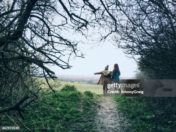 due giovani amici in campagna camminano indicando la strada da percorrere - sussex occidentale foto e immagini stock
