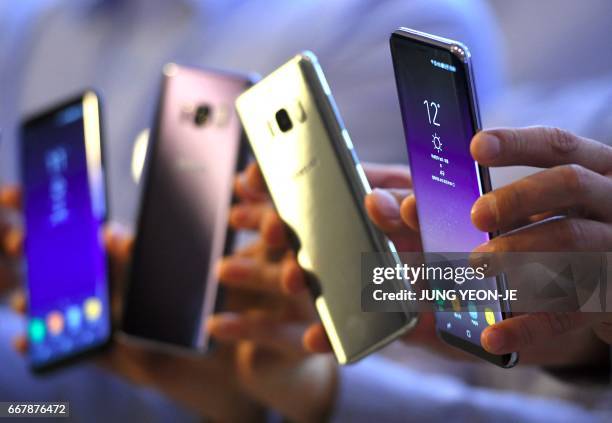 South Korean models show Samsung Galaxy S8 smartphones during a showcase to mark the domestic launch of Samsung Electronics' latest flagship...