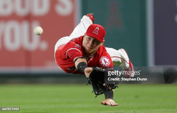 Right fielder Kole Calhoun of the Los Angeles Angels of Anaheim dives but can't catch a ball that went for a single off the bat of Jonathan Lucroy of...