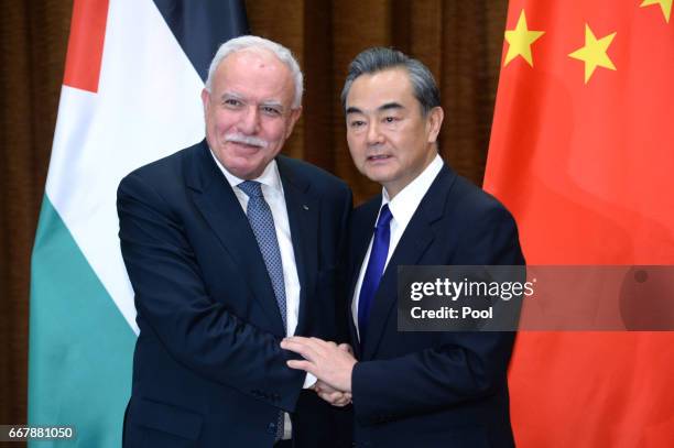 Palestinian Foreign Minister Riyad Al-Maliki, left, talks with Chinese Foreign Minister Wang Yi before their meeting at the Ministry of Foreign...