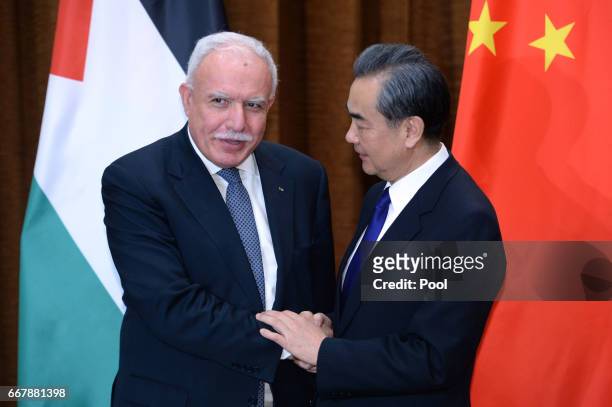Palestinian Foreign Minister Riyad Al-Maliki, left, talks with Chinese Foreign Minister Wang Yi before their meeting at the Ministry of Foreign...