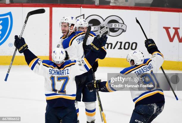 Jaden Schwartz, Ivan Barbashev and Vladimir Tarasenko of the St. Louis Blues congratulate teammate Joel Edmundson on scoring the game-winning goal...