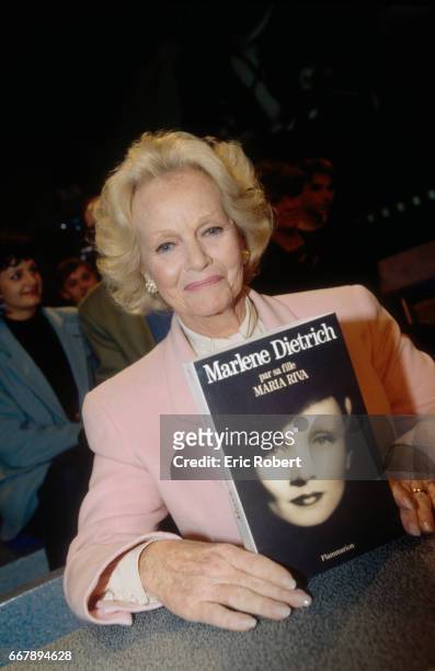 Portrait of Maria Riva, daughter of Marlene Dietrich, with the book she wrote on her mother.