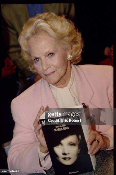 Portrait of Maria Riva, daughter of Marlene Dietrich, with the book she wrote on her mother.
