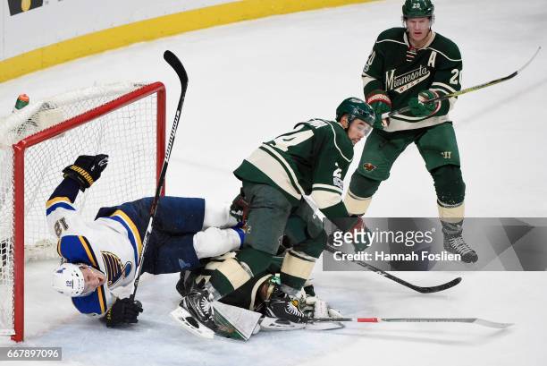 Jori Lehtera of the St. Louis Blues crashes into the net after tripping over Devan Dubnyk and Matt Dumba of the Minnesota Wild as Ryan Suter looks on...